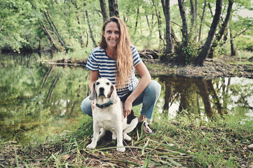 Naklejka na ściany i meble attractive young woman in the outdoors posing with a beagle dog 