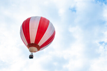 Naklejka premium Balloon in the blue sky. Red balloon in the blue cloudy sky.