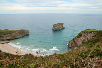 Fototapeta premium View of the coast, the Cantabrian Sea and the `La Soledad` beach from `El Tunel` in Laredo on a cloudy day
