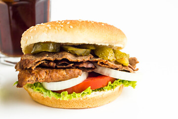 Delicious Burger made with Traditional Turkish Doner Kebab,tomato,pickle,lettuce and onion rings on the white background with cold drink.