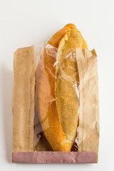 Daily fresh and crispy breads in transparent kraft paper bag on the white background with copy space