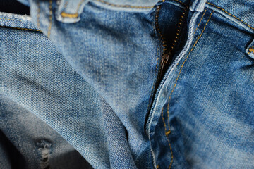 Fototapeta premium Zipper of ripped denim pants. Textile, denim background. Fashion, tailoring, clothing repair concept.