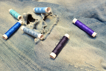 Ripped jeans and threads for clothing repair.