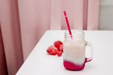 Frozen strawberry smoothies on a white table.