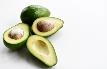 Fresh avocado slices on white table background closeup composition with free text copy space