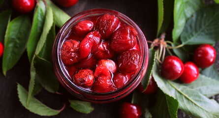 Closeup cherry jam in a jar, harvesting for winter, selective focus.