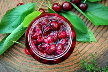 Closeup cherry jam in a jar, harvesting for winter, selective focus.