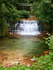 Waterfall of river gerês that runs between the trees before fall throw the rock steps and enter the village