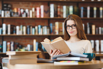 Attractive young girl student with lots of books, studying