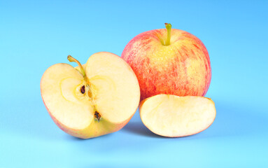 Fresh apple and sliced on blue background.
