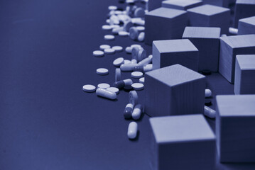 pills ampoules scattered on the background together with wooden cubes, health concept without pills
