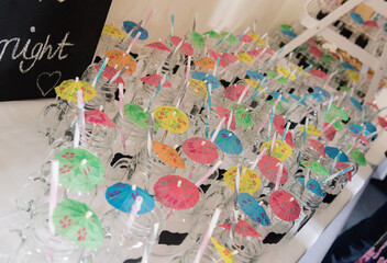 Jars with cocktail umbrellas for party
