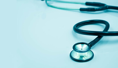 Close-up of Black stethoscope of doctor for checkup on light blue background. Stethoscope equipment of medical use to diagnose hear sound. Health care and cardiology concept with copy space.