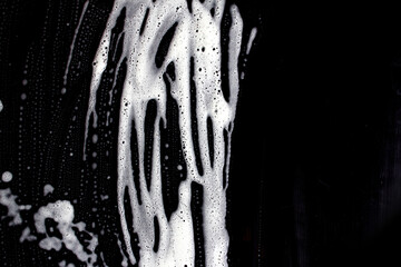 The texture of the soap foam stains marks on a black background.
