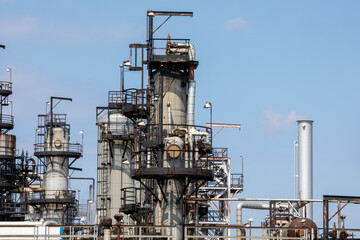 Petro chemical refinery pipes and cracking towers against a blue sky
