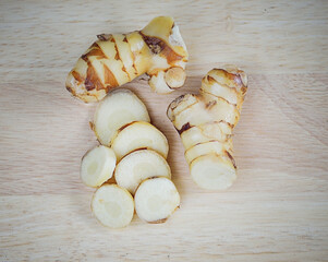 fresh galangal on wooden surface background.