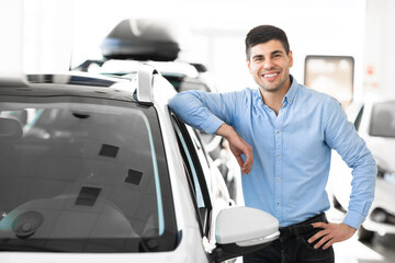 Guy Standing Near Auto In Car Showroom