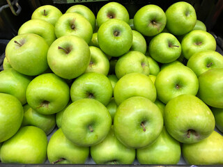 Fototapeta na wymiar Background of fresh green apples on sale at the local market