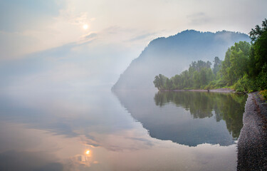 Wild lake in Siberia. Misty morning, sunrise, mystical view.