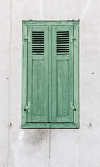 Old green window with closed wooden shutters