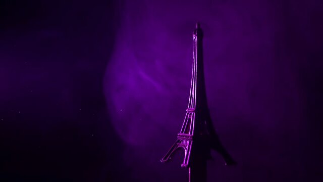 Miniature of Eiffel Tower with purple light on it and smoke