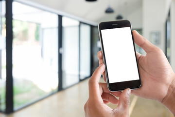 Cropped shot view of man hands holding smart phone with blank copy space screen for your text message or information content, female reading text message on cell telephone during in urban setting. 