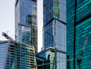 Modern skyscrapers from glass walls with reflections and construction cranes, Moscow city office business center.