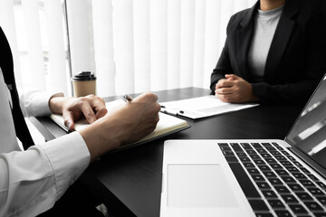 Interview employee talking about resume and job description with the job seeker sitting in front