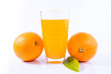 glass of orange juice and oranges