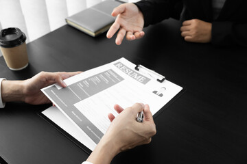 Interview employee reading a resume with the job seeker sitting in front