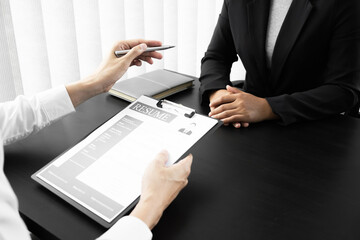 Interview employee reading a resume with the job seeker sitting in front