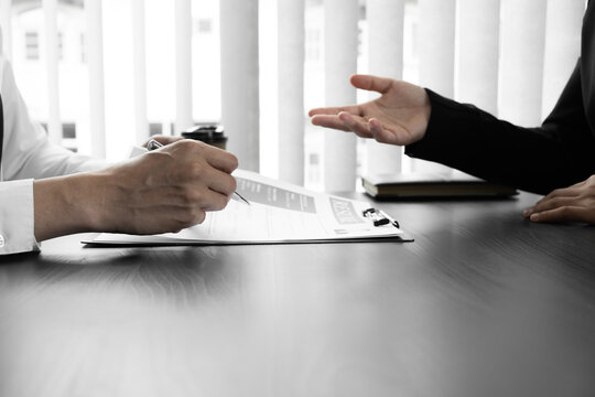 Interview employee reading a resume with the job seeker sitting in front
