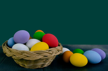 Rainbow color of egg in rattan basket and on the floor