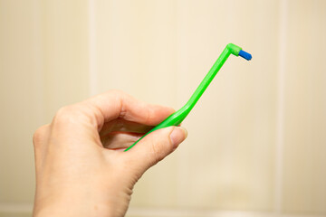 Green toothbrush with a single beam for braces in hand.
