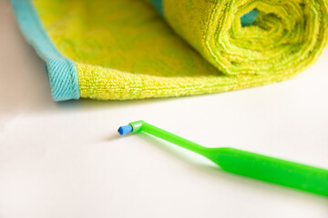 Green toothbrush with a one tuft for braces on a table