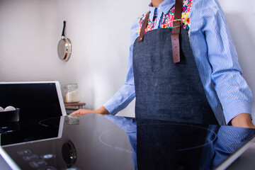 An unrecognizable woman wearing an apron at kitchen