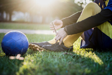 footballer tying the laces of his soccer boot