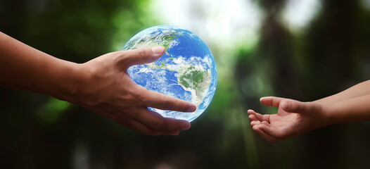 concept - hands of adult giving planet earth to child - elements of this image furnished by NASA