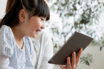 タブレットPCを見る親子