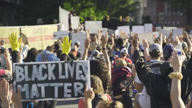 Black Lives Matter protesters kneeling holding hands up