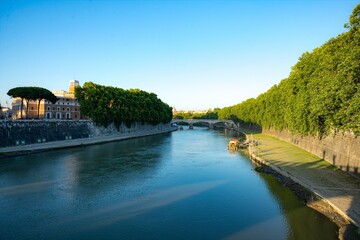 Fototapeta premium Tranquil evening view on the river Tiber in Rome with bridges in the shadow of sunset
