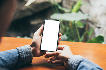 cell phone mockup image blank white screen.woman hand holding texting using mobile on desk at coffee shop.background empty space for advertise.work people contact marketing business,technology