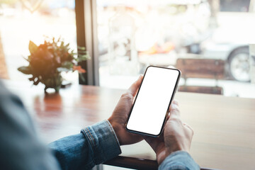 cell phone mockup image blank white screen.woman hand holding texting using mobile on desk at coffee shop.background empty space for advertise.work people contact marketing business,technology