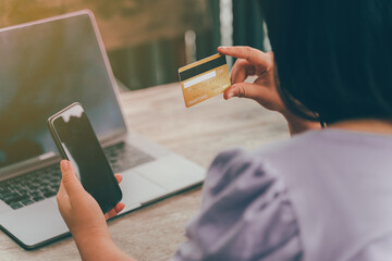 Online payment, hands holding a credit card and using smart phone for online shopping
