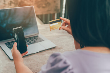 Online payment, hands holding a credit card and using smart phone for online shopping
