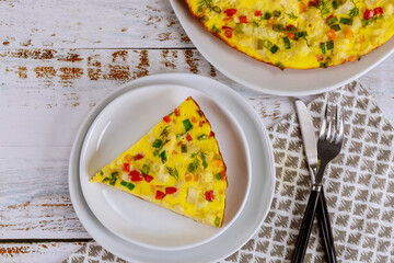 Colorful scrambled eggs with vegetables on white plate.