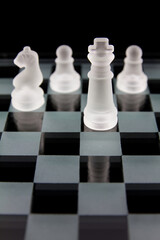Close-up side view of glass chess board with black colour background