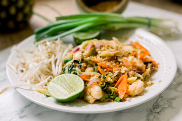 Vegetable Pad Thai with Shrimp with Zucchini Noodles. This plate is garnished with bean sprouts, green onions, and a lime wedge. 