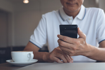 Asian casual business man using mobile smart phone in coffee shop