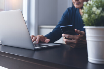 Asian casual man working on laptop computer surfing internet at home 